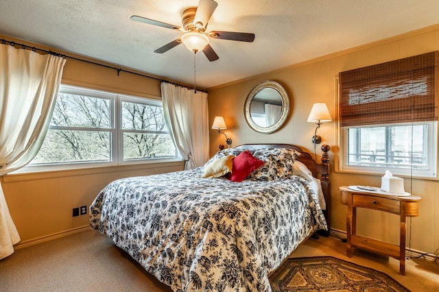 carpeted bedroom with a ceiling fan, ornamental molding, and a textured ceiling