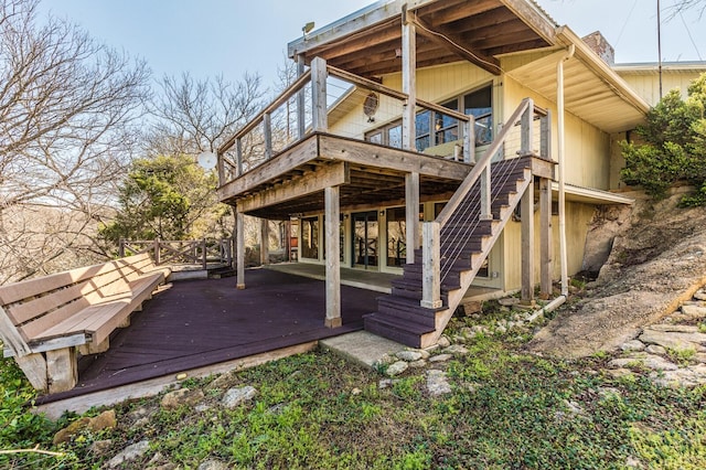 back of property with a wooden deck and stairs