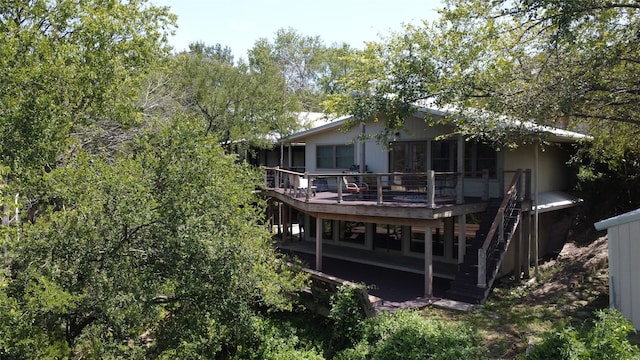 back of house featuring stairway and a wooden deck