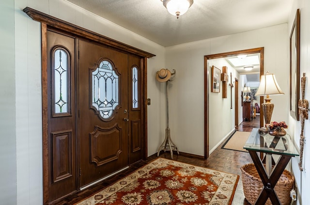 entrance foyer with baseboards and a textured ceiling