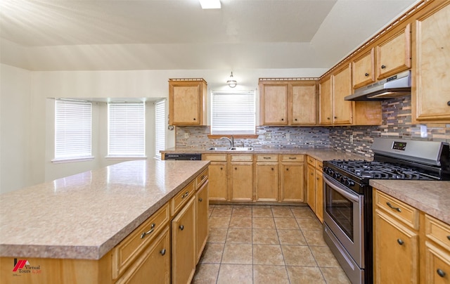 kitchen featuring under cabinet range hood, a sink, tasteful backsplash, light tile patterned flooring, and gas range