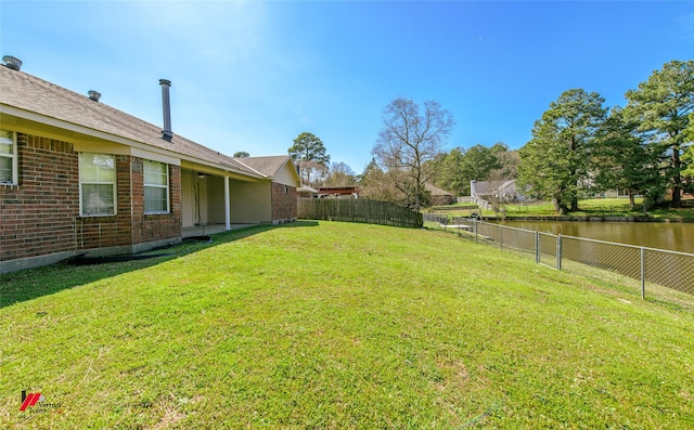 view of yard featuring a fenced backyard and a water view