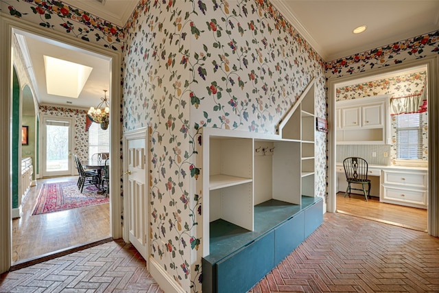 interior space featuring ornamental molding, a chandelier, and light hardwood / wood-style floors