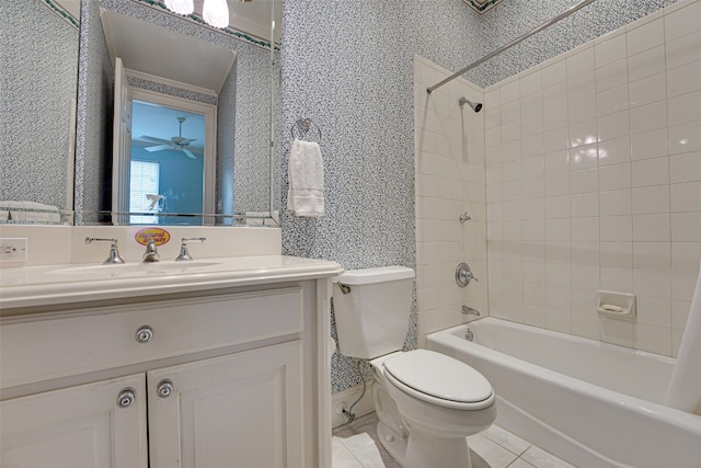 full bathroom featuring oversized vanity, toilet, tile flooring, tiled shower / bath, and ceiling fan