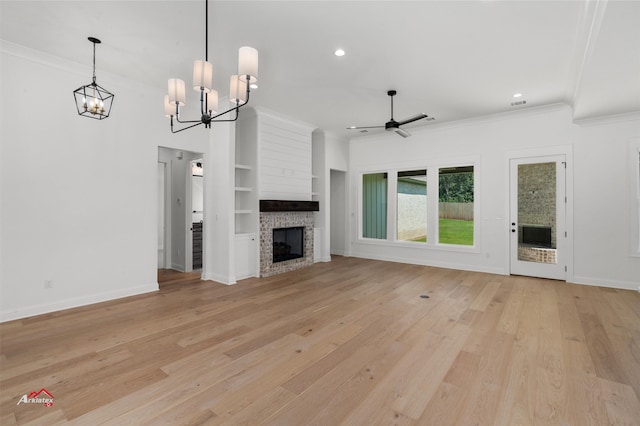 unfurnished living room with light hardwood / wood-style flooring, a fireplace, ceiling fan with notable chandelier, built in shelves, and ornamental molding