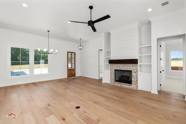 unfurnished living room with light hardwood / wood-style floors, a healthy amount of sunlight, and ceiling fan with notable chandelier