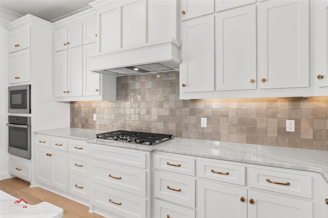 kitchen featuring backsplash, appliances with stainless steel finishes, white cabinetry, and light hardwood / wood-style floors