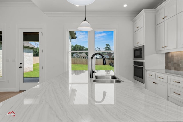 kitchen with white cabinets, a wealth of natural light, backsplash, and stainless steel appliances