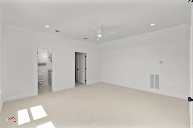 unfurnished bedroom featuring light colored carpet, ensuite bathroom, ceiling fan, and crown molding