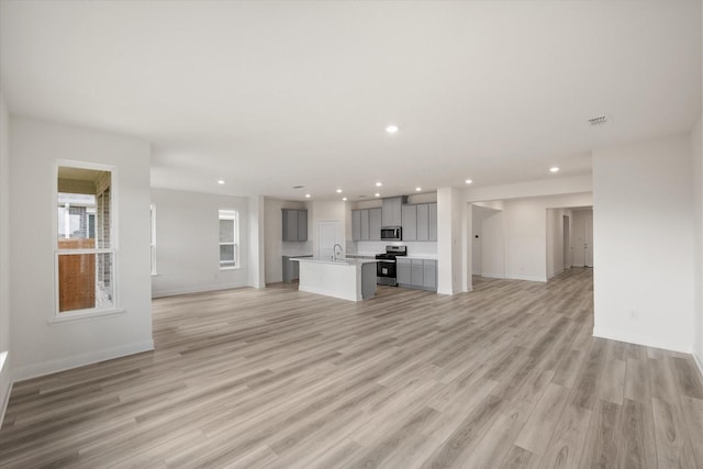 unfurnished living room featuring light hardwood / wood-style floors and sink