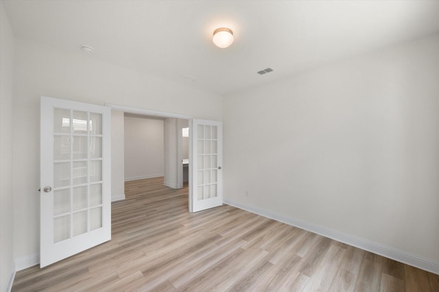 unfurnished room with french doors and light hardwood / wood-style floors