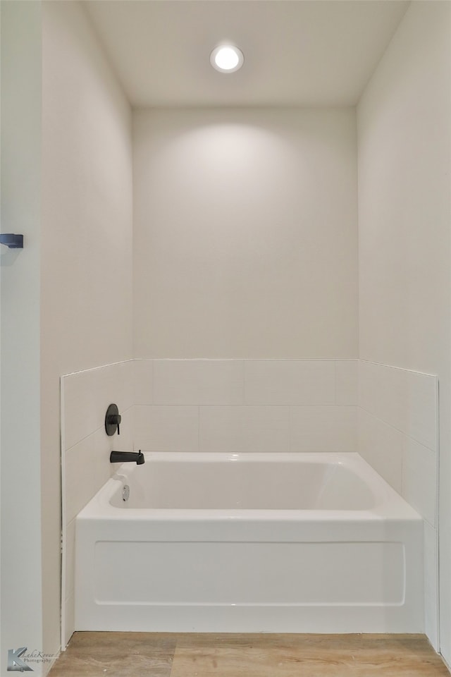 bathroom with hardwood / wood-style flooring and a bathing tub