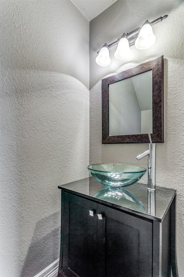 bathroom featuring a textured wall and vanity