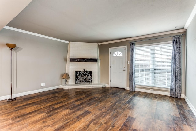 unfurnished living room with ornamental molding, a fireplace, wood finished floors, and baseboards