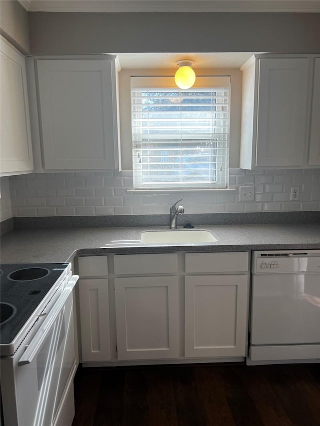 kitchen featuring white appliances, decorative backsplash, dark wood-type flooring, white cabinetry, and a sink