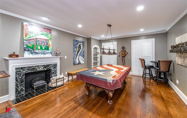 recreation room with baseboards, a premium fireplace, ornamental molding, wood finished floors, and recessed lighting