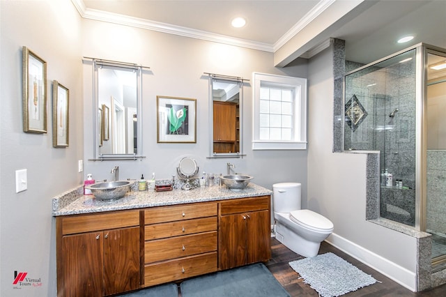 full bath with a shower stall, a sink, toilet, and crown molding