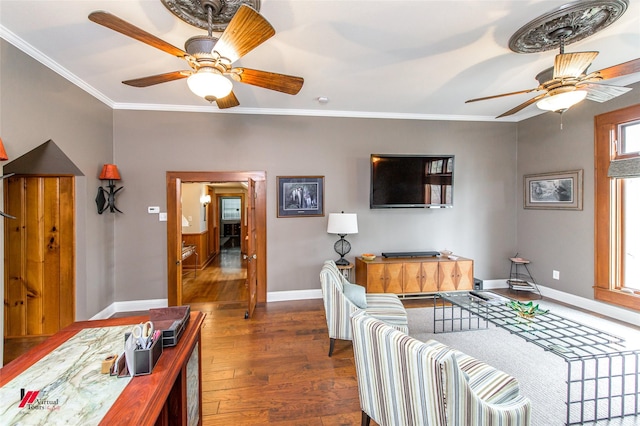 living room featuring baseboards, ceiling fan, hardwood / wood-style flooring, and crown molding