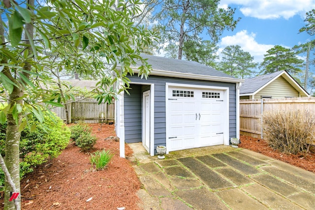 detached garage with driveway and fence