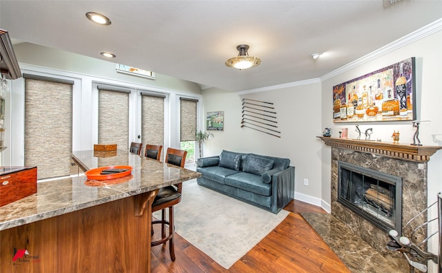 living area featuring crown molding, a fireplace, recessed lighting, dark wood-type flooring, and baseboards