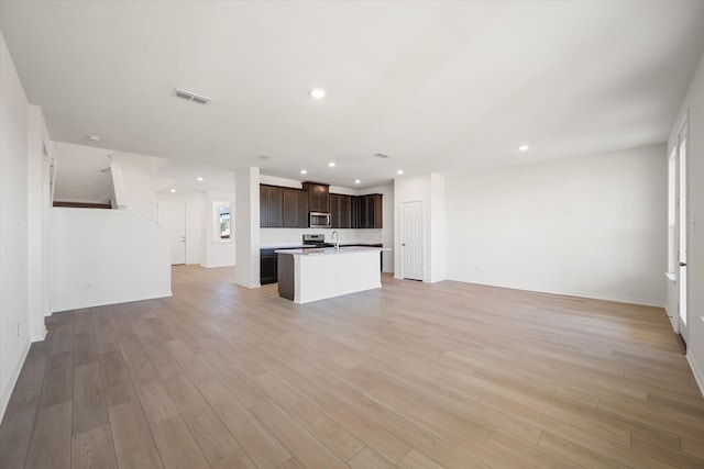 unfurnished living room with light hardwood / wood-style flooring and sink