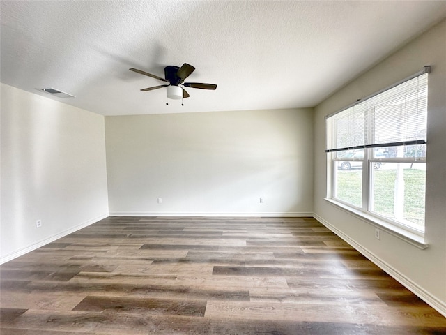 spare room featuring a textured ceiling, ceiling fan, and dark hardwood / wood-style flooring