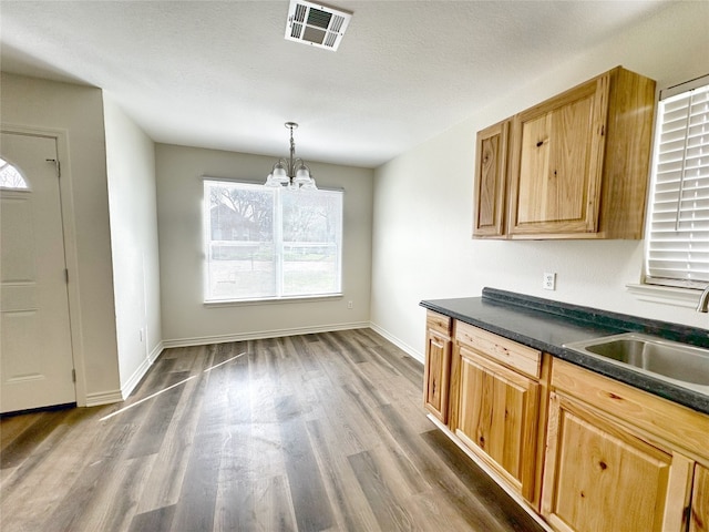 kitchen featuring sink, a chandelier, dark hardwood / wood-style flooring, and pendant lighting