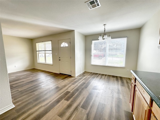 foyer entrance with dark hardwood / wood-style floors and a chandelier