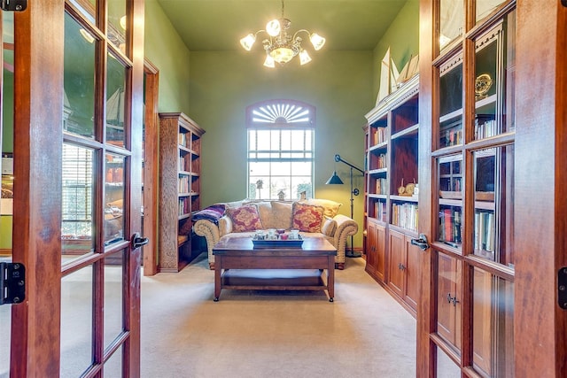 sitting room with light carpet, french doors, and an inviting chandelier