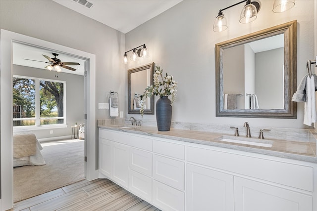 bathroom featuring a tub to relax in, vanity, and ceiling fan