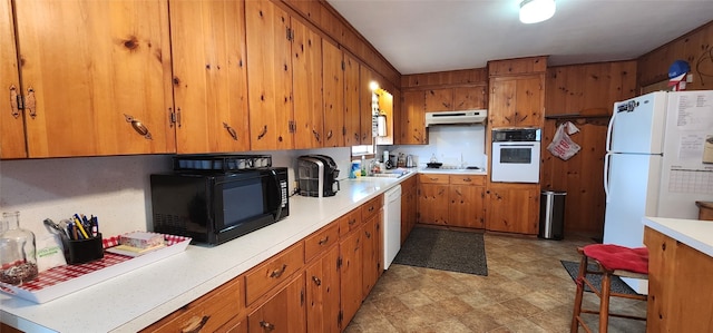 kitchen featuring white appliances, sink, and light tile floors