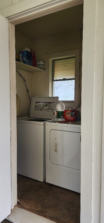 laundry area featuring washer and dryer and dark tile flooring