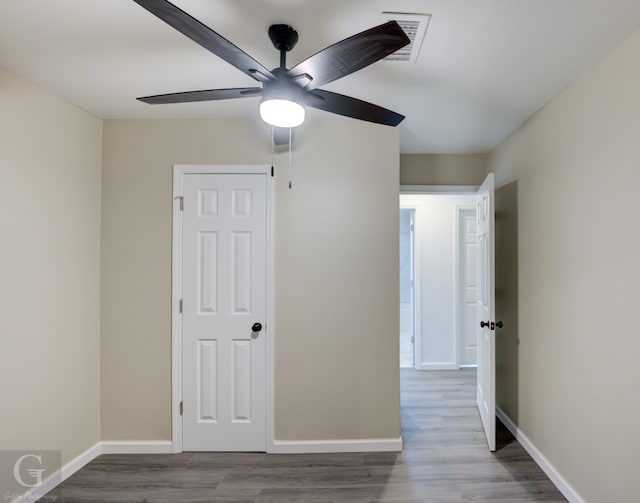 empty room featuring dark hardwood / wood-style flooring and ceiling fan