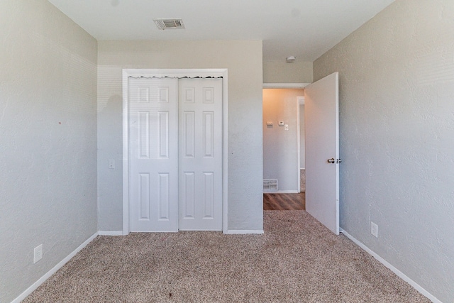 unfurnished bedroom featuring carpet and a closet