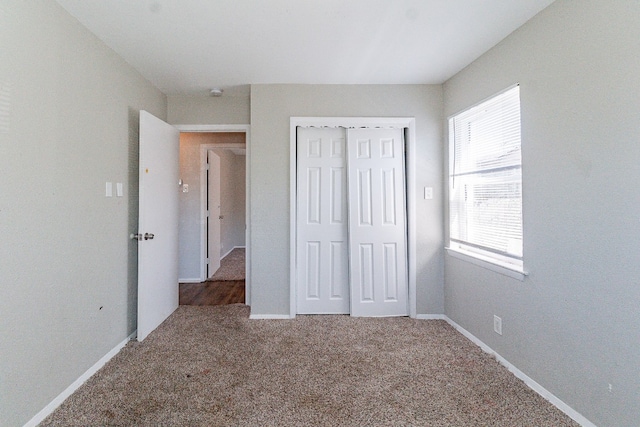 unfurnished bedroom featuring carpet flooring and a closet