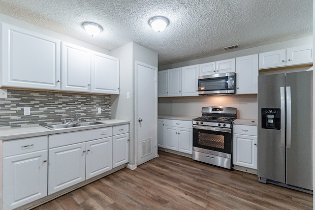 kitchen with dark hardwood / wood-style floors, white cabinetry, and stainless steel appliances