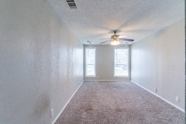 carpeted spare room with ceiling fan and a textured ceiling