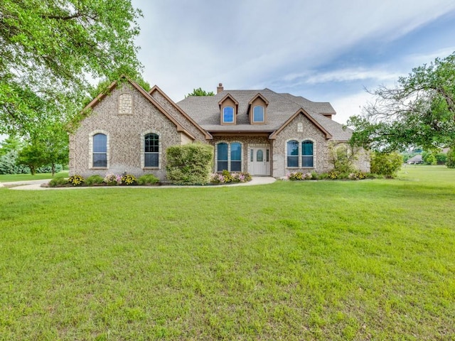 102 Apollo Trl, Aurora, TX 76078 - french country home featuring a chimney, brick siding, a front lawn, and roof with shingles
