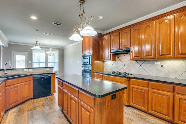 kitchen featuring a kitchen island, decorative light fixtures, black appliances, and light wood-type flooring