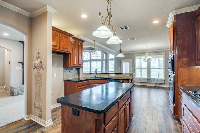 kitchen with oven, stainless steel microwave, dark wood-type flooring, a kitchen island, and tasteful backsplash