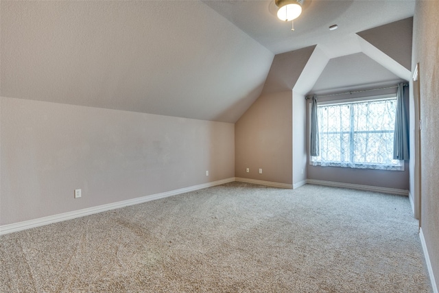 additional living space with ceiling fan, lofted ceiling, and light carpet