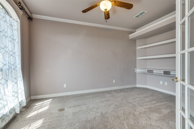 carpeted empty room with ceiling fan, crown molding, and french doors