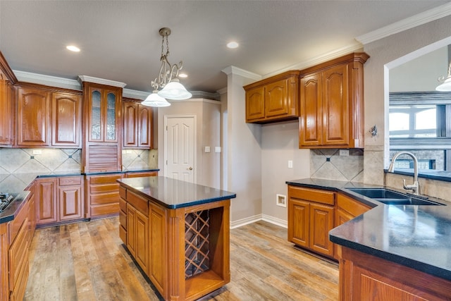 kitchen with a chandelier, backsplash, a kitchen island, and sink