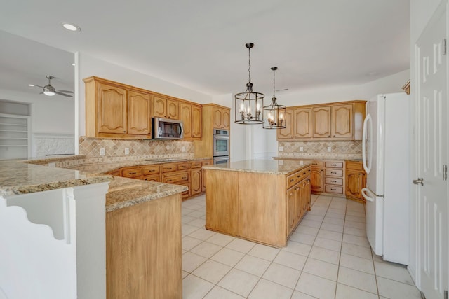 kitchen featuring pendant lighting, ceiling fan with notable chandelier, light stone countertops, white fridge, and kitchen peninsula