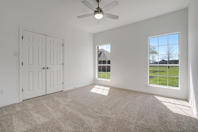 unfurnished bedroom featuring carpet, ceiling fan, and a closet