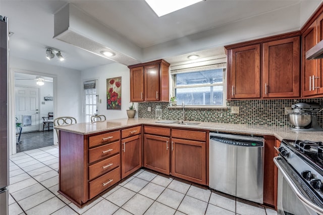 kitchen with ceiling fan, appliances with stainless steel finishes, light tile flooring, and kitchen peninsula