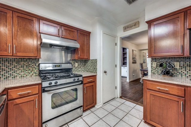 kitchen featuring backsplash, light tile floors, stainless steel appliances, and light stone countertops