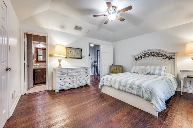 bedroom featuring vaulted ceiling, ceiling fan, ensuite bath, and dark wood-type flooring