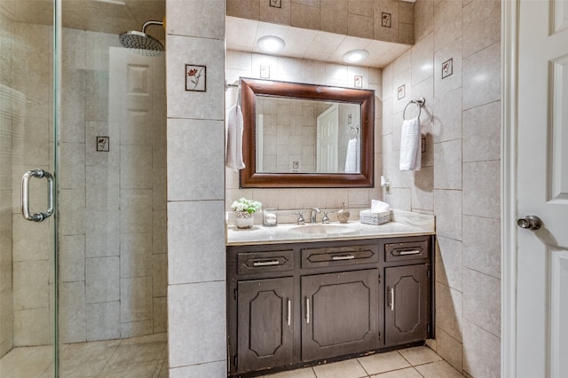 bathroom with walk in shower, tile floors, tile walls, and vanity