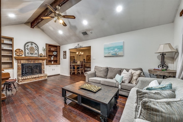 living room featuring a fireplace, ceiling fan with notable chandelier, dark wood-type flooring, built in shelves, and lofted ceiling with beams